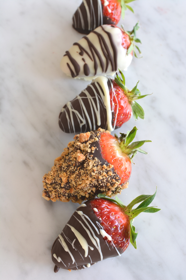 an image of a row of strawberries coated in a variety of toppings, including crushed nuts, white chocolate, and dark chocolate