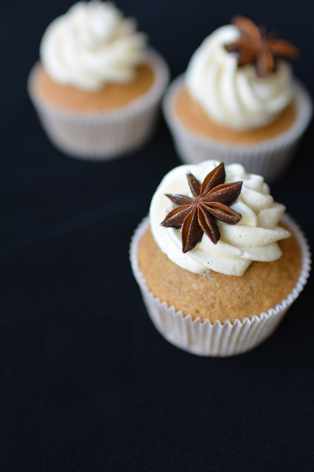 close up view of a chai tea spiced cup cake with swirl of buttercream and star anise on the top.