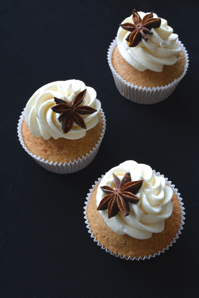 top view image of three chai tea spiced cupcakes adorned with buttercream frosting and garnished with a decorative piece of star anise
