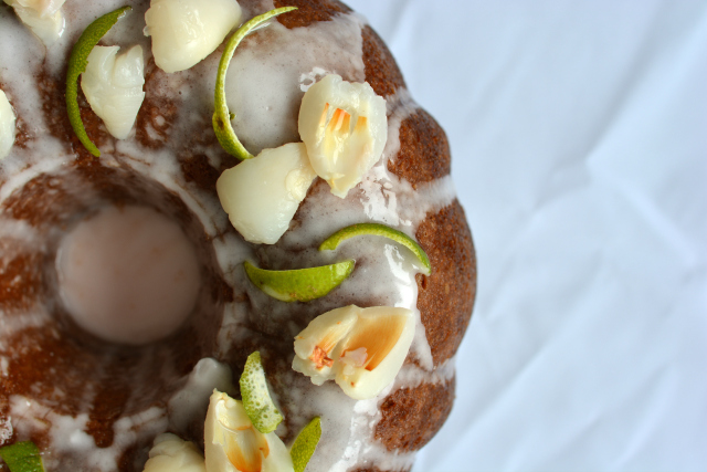 overhead view of half of the Lime and Lychee Bundt Cake, drizzled with icing and garnished with lime zest and lychee