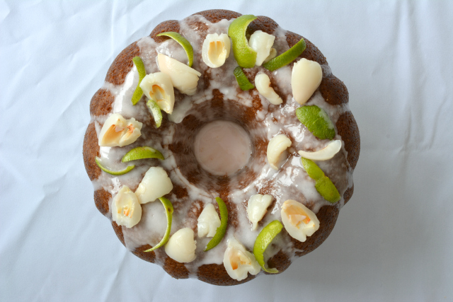 top-down view of a Lime and Lychee Bundt Cake, elegantly drizzled with icing and garnished with fresh lychee and lime zest